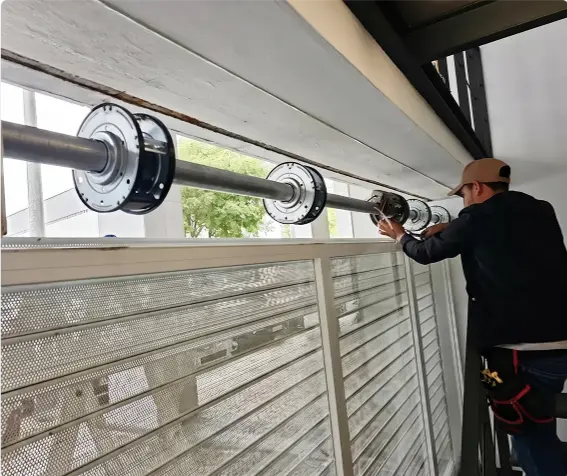 Técnico realizando manutenção em motor de portão de rolo industrial